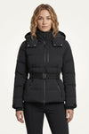 A woman modeling a black hooded puffer jacket with a front zipper, snap details on the chest, and a matching black belt, set against a plain off-white studio background.