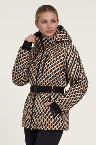 A woman wearing a beige and black geometric patterned hooded puffer jacket with a black belt, photographed against a plain light background.