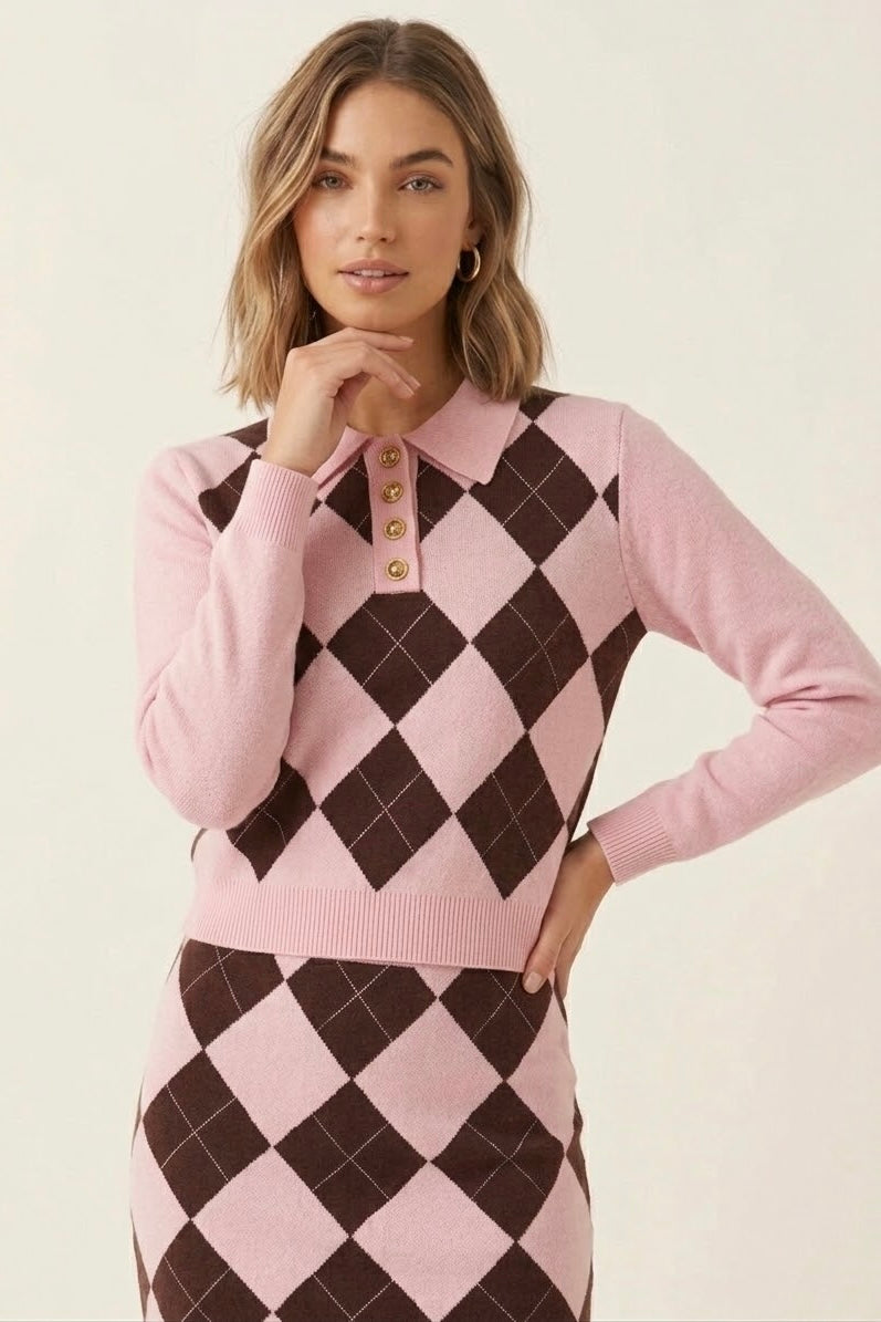 A woman modeling a pink and dark brown argyle knit polo sweater and matching argyle skirt against a plain light beige studio background.